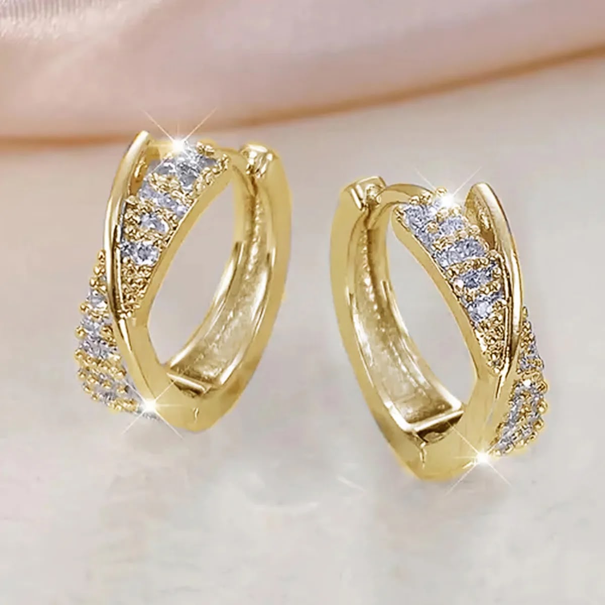 Aretes huggies dorados infinito entrelazado circonias blancas