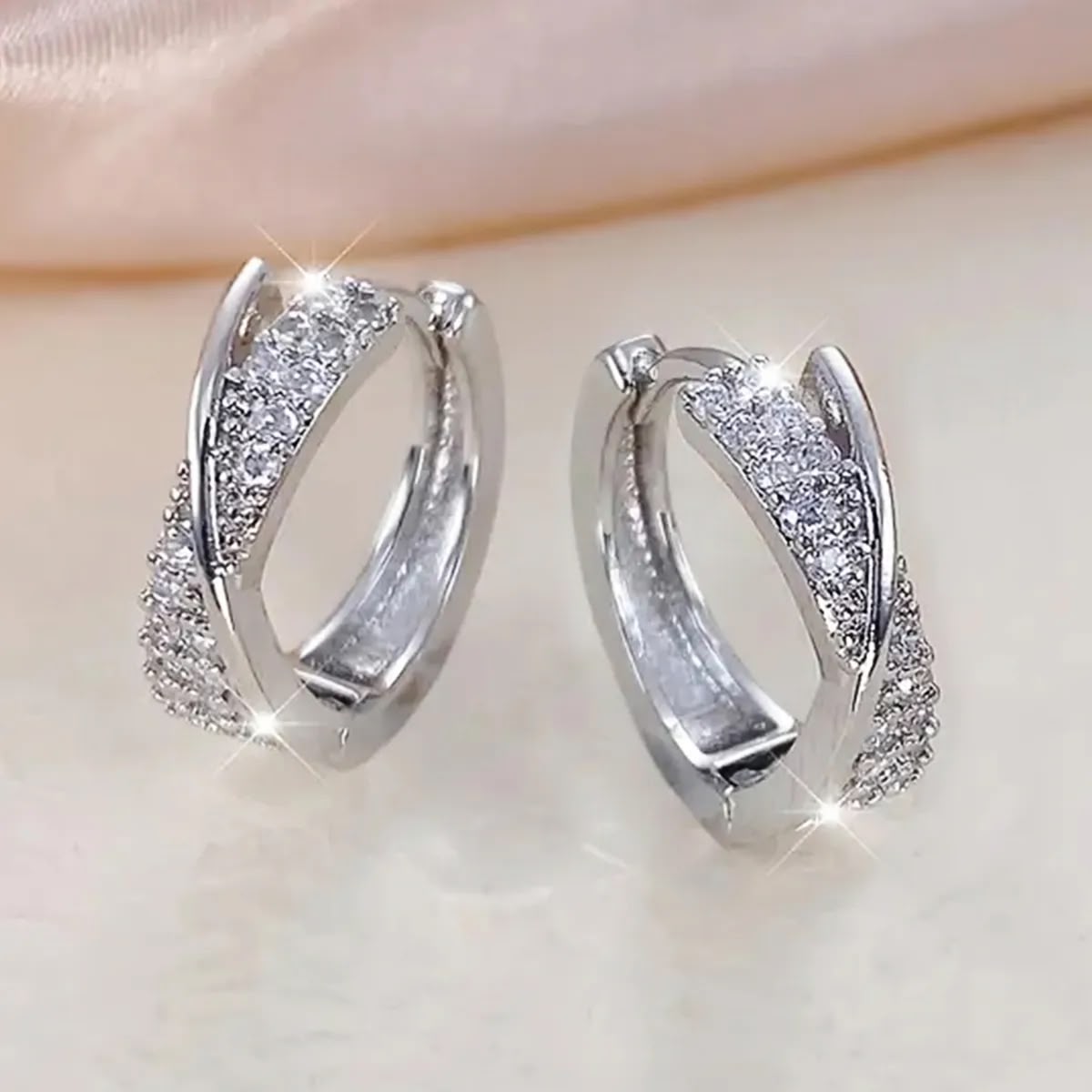 Aretes huggies plateados infinito entrelazado circonias blancas